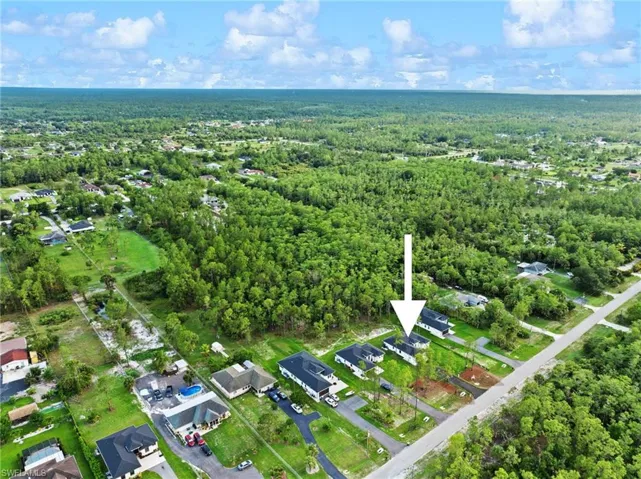 Aerial view of property and surrounding area featuring nearby suburban area