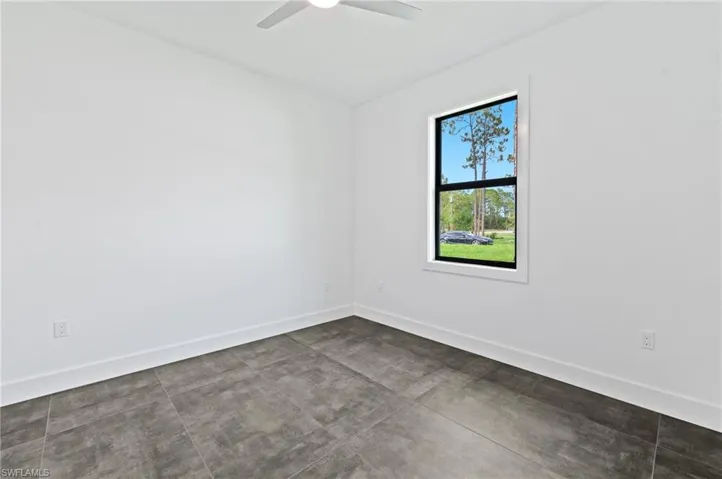 Empty room featuring concrete floors and ceiling fan