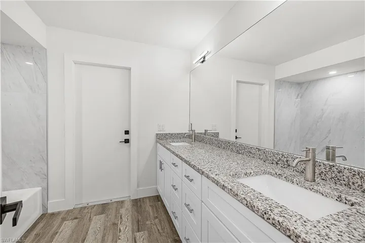 Dual-sink vanity with speckled countertop, undermount sinks, and brushed nickel fixtures