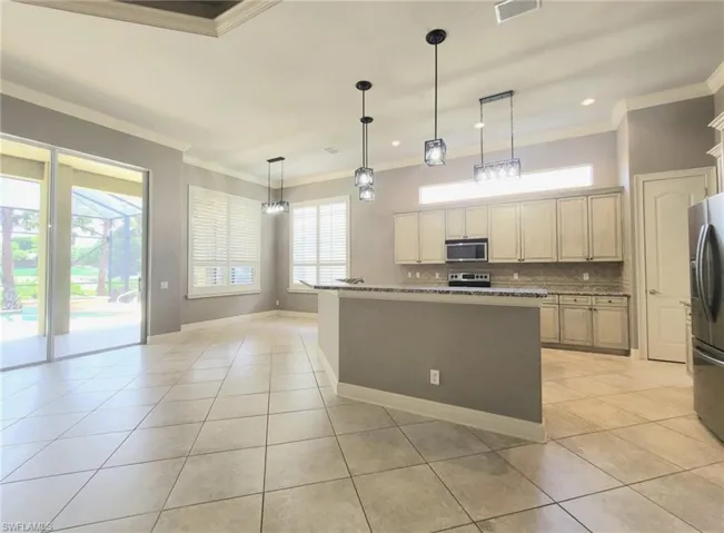Kitchen with new lighting fixtures and also recessed lights.
