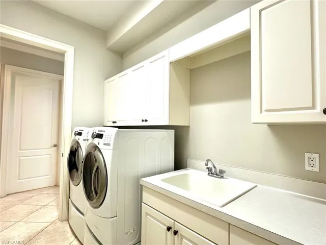 Laundry room with newer washer and dryer and sink.