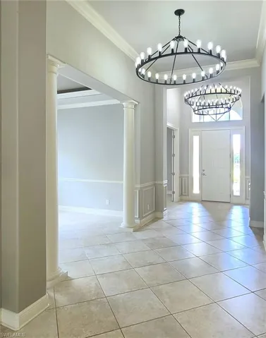 Tiled foyer with decorative columns, and new contemporary lighting fixtures