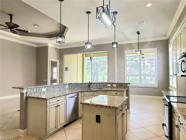 Open kitchen with granite countertops, island for food preparation and customized cabniets.