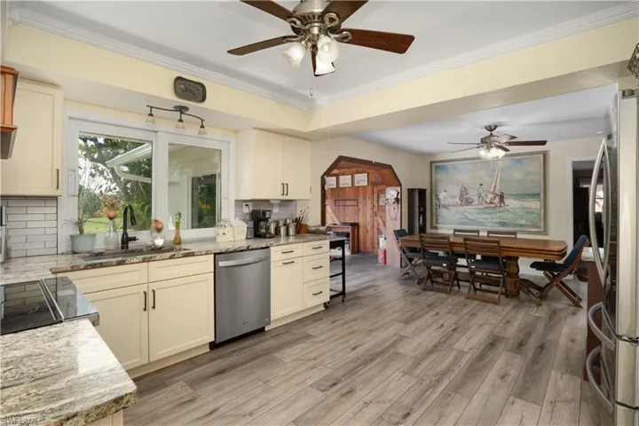 Kitchen featuring stainless steel appliances, light stone countertops, sink, and light wood-type flooring
