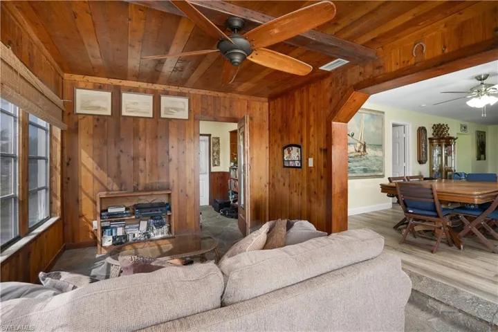 Living room featuring wood ceiling, wooden walls, and wood-type flooring