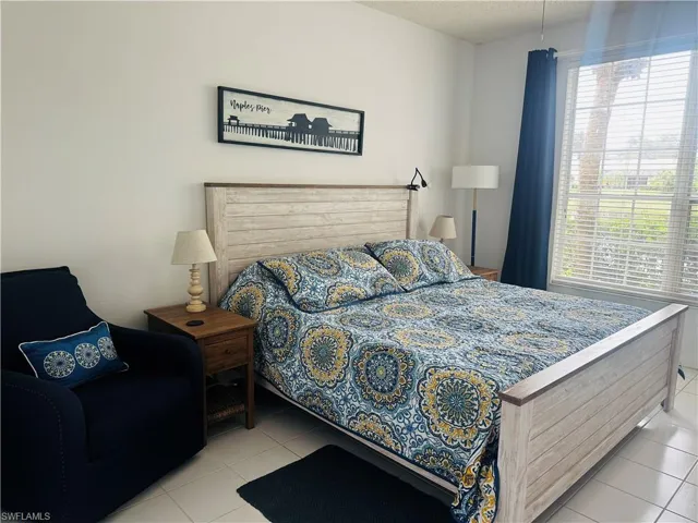 Bedroom with light tile patterned flooring and a textured ceiling