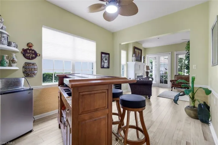 Open-concept living space featuring light wood-finish flooring and a built-in bar area