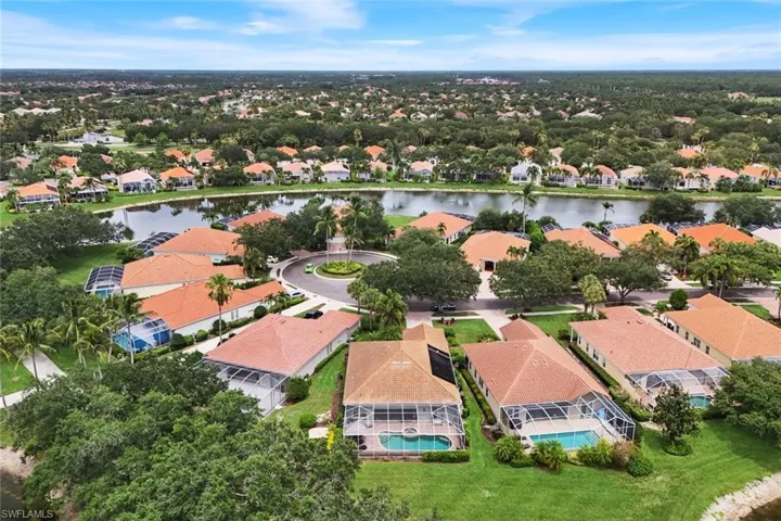 Aerial perspective showcasing a property with a screen-enclosed pool and spa