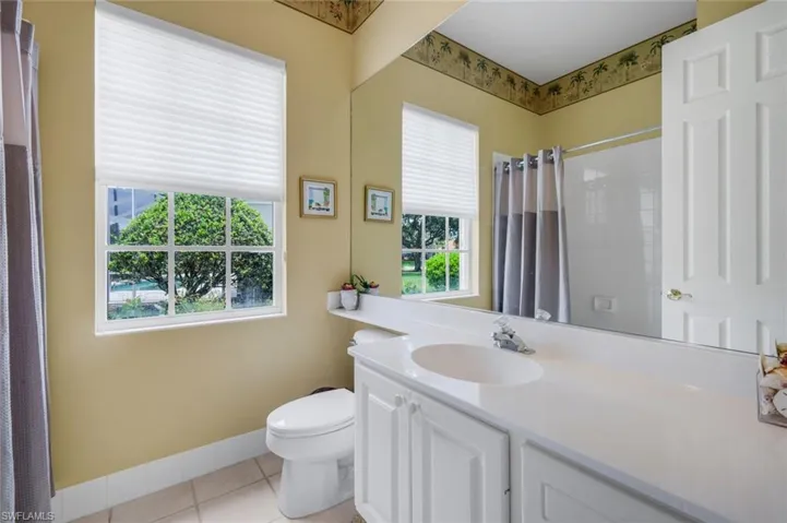 Room featuring wall-to-wall carpeting, light green painted walls, and a white ceiling fan