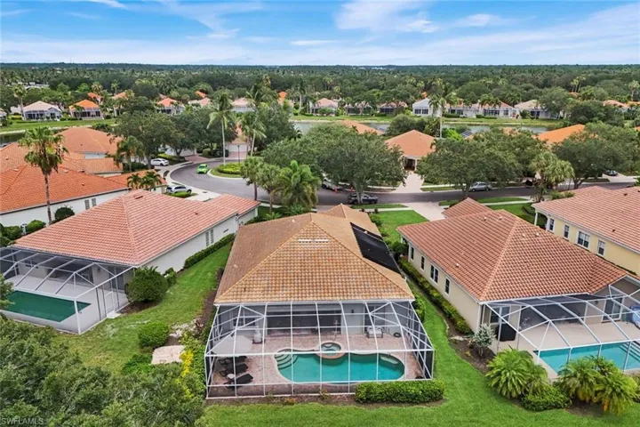 Aerial perspective showcasing a residential community with a winding lake feature and mature landscaping