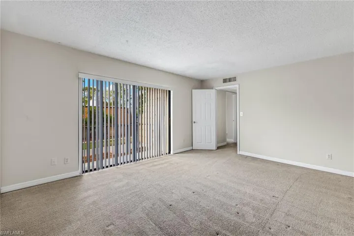 Unfurnished room with a textured ceiling and carpet flooring
