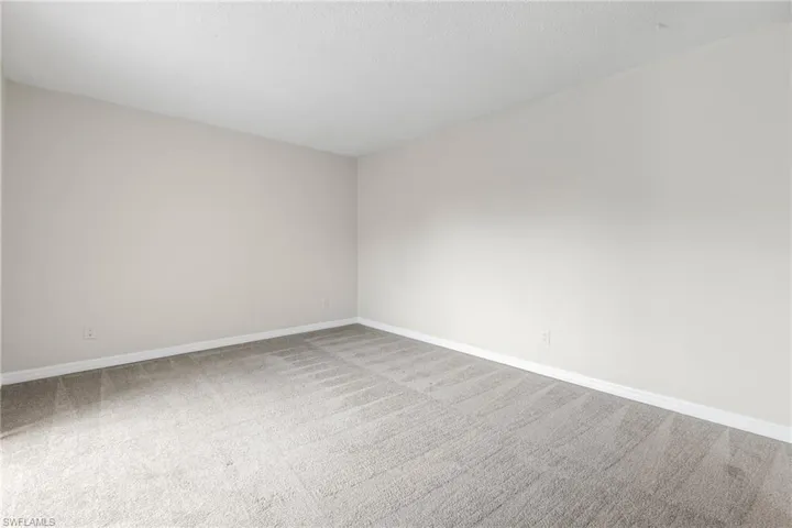 Empty room with carpet floors and a textured ceiling