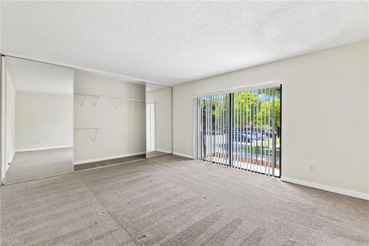 Unfurnished living room featuring light carpet and a textured ceiling