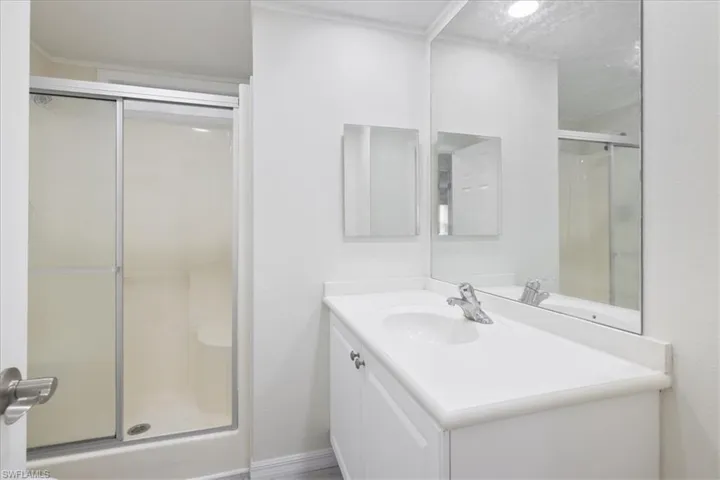 Full bath with a shower stall and vanity