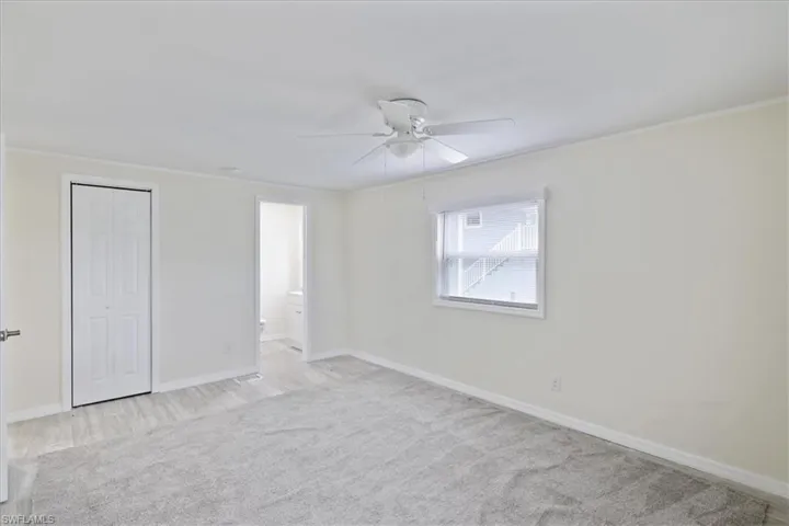 Unfurnished bedroom with carpet flooring, ceiling fan, a closet, ornamental molding, and ensuite bathroom