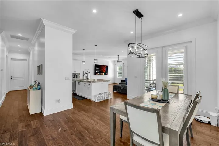 Dining area with crown molding, recessed lighting, and dark wood-style floors
