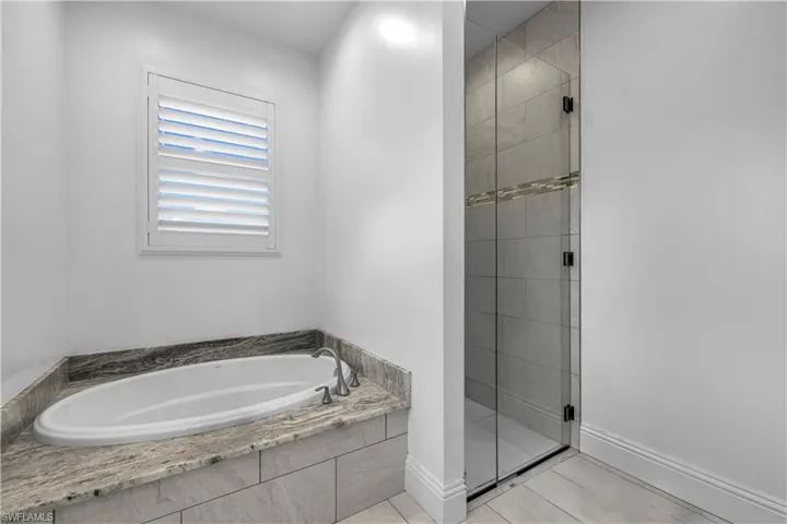Bathroom with a bath and a stall shower