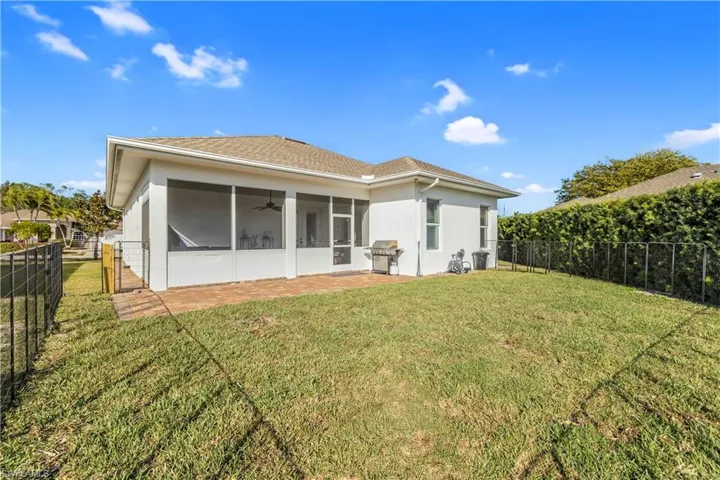 Back of house with a fenced backyard, a sunroom, ceiling fan, stucco siding, and roof with shingles
