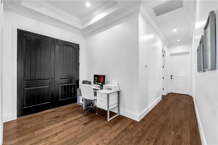Office area featuring ornamental molding, dark wood-style floors, recessed lighting, and a raised ceiling