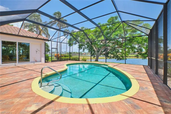 View of patio / terrace featuring ceiling fan, an outdoor pool, outdoor dining space, a water view, and glass enclosure