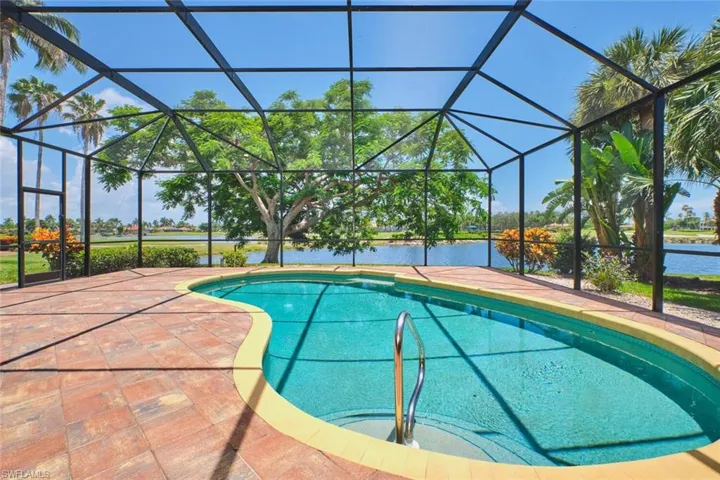 View of patio featuring a ceiling fan, an outdoor pool, outdoor dining area, a water view, and a lanai