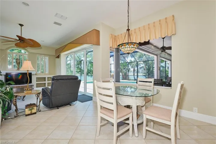Tiled dining space featuring a ceiling fan and baseboards