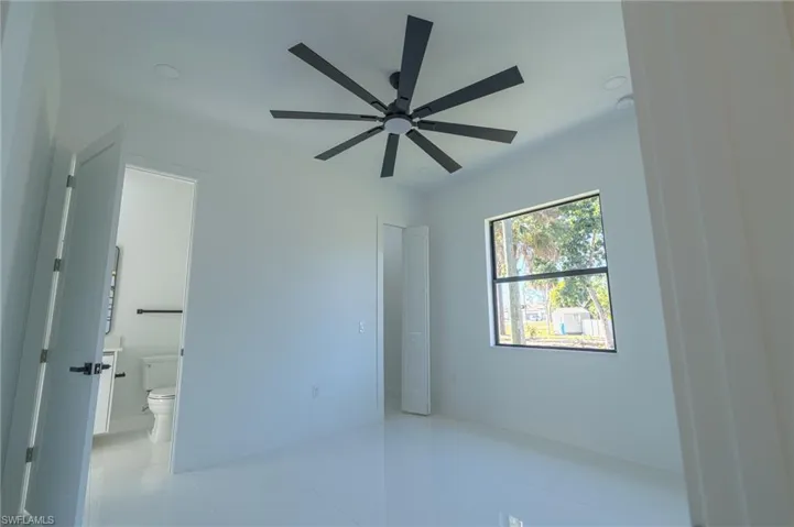 Unfurnished bedroom with light tile patterned floors and ceiling fan