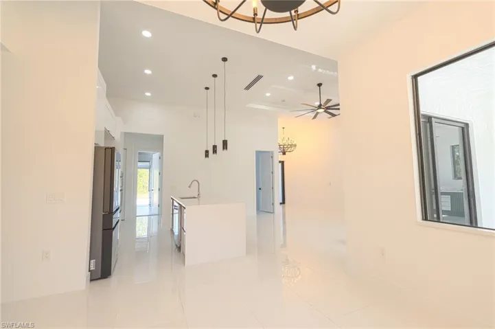 Kitchen with white cabinetry, a chandelier, a center island with sink, decorative light fixtures, and recessed lighting