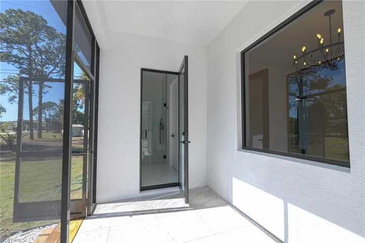 View of exterior entry with a sunroom and stucco siding