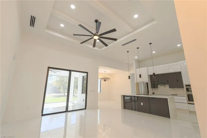 Kitchen with white cabinets, recessed lighting, a large island, pendant lighting, and a chandelier