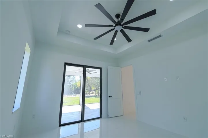 Unfurnished room with recessed lighting, a raised ceiling, ceiling fan, and light tile patterned flooring