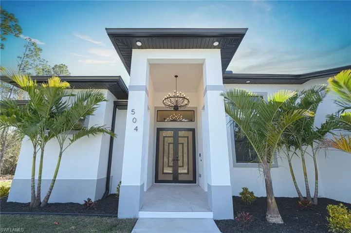 Entrance to property featuring stucco siding and french doors