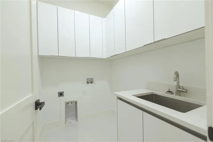 Washroom featuring hookup for a washing machine, hookup for an electric dryer, and cabinet space