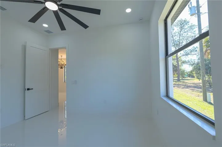 Tiled spare room with recessed lighting and a chandelier