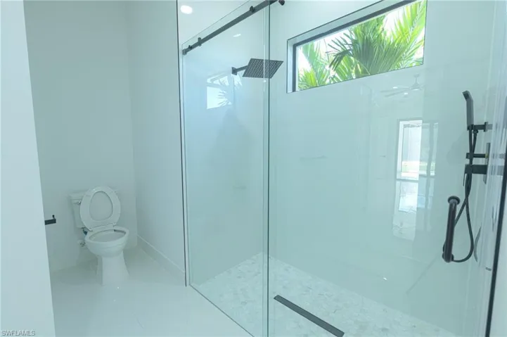 Full bathroom featuring a walk in shower and toilet