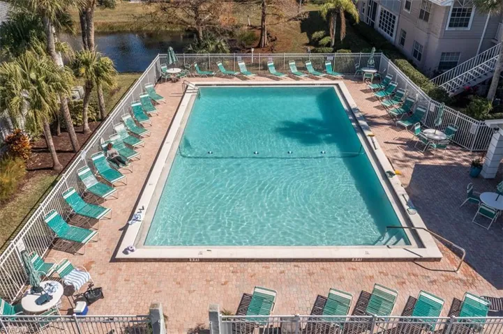 Community pool featuring a water view and a patio