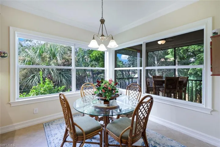 Dining room with a healthy amount of sunlight, light tile patterned floors, and a chandelier