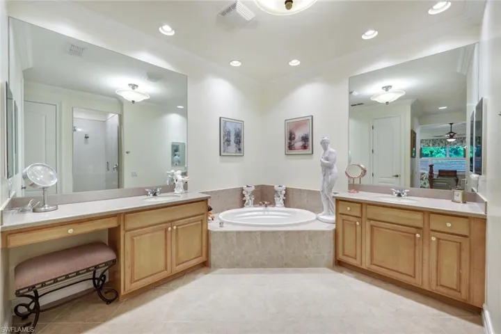 Bathroom featuring ceiling fan, independent shower and bath, vanity, and crown molding
