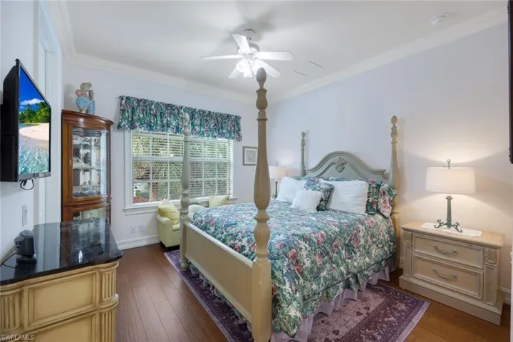 Bedroom featuring ceiling fan, crown molding, and dark hardwood / wood-style flooring