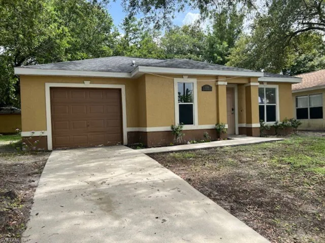 View of front facade featuring an attached garage, stucco siding, and concrete driveway