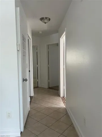 Hall with light tile patterned floors and baseboards