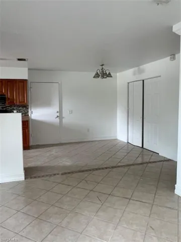 Unfurnished room featuring a chandelier and light tile patterned floors