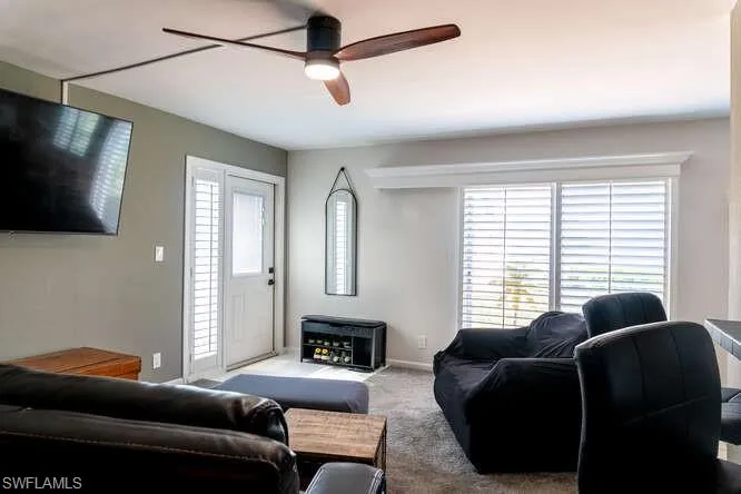 Carpeted living room with ceiling fan