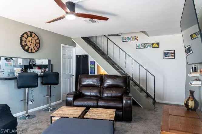 Carpeted living room with ceiling fan