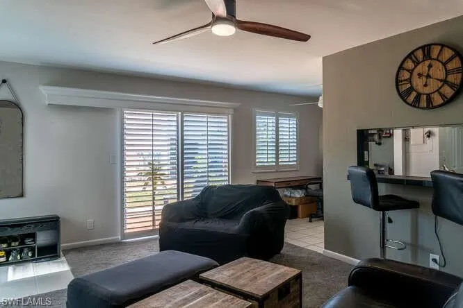 Carpeted living room with ceiling fan