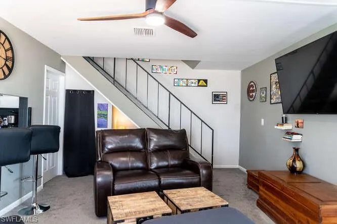 Living room featuring ceiling fan and carpet floors