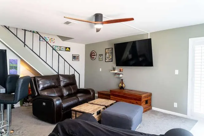 Carpeted living room with ceiling fan