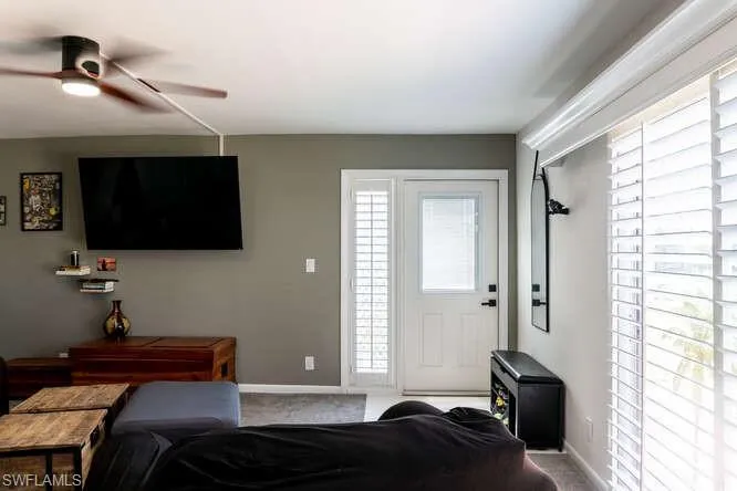 Living room featuring ceiling fan and carpet flooring
