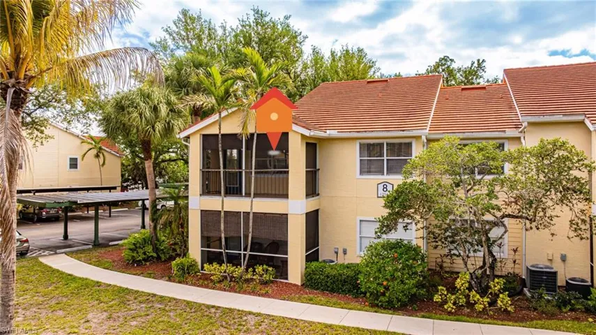 Multi-level residence featuring a screened upper balcony and lower patio, surrounded by mature palm trees