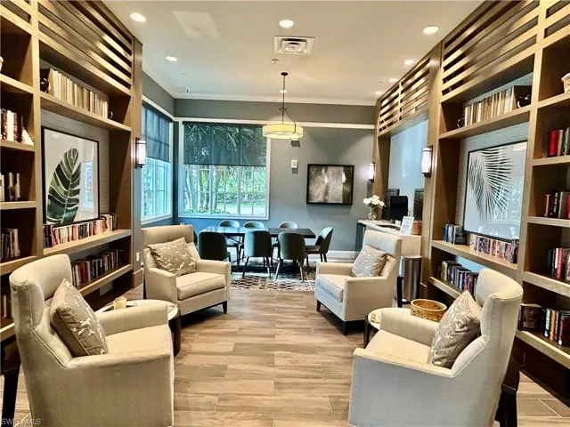 Sitting room with ornamental molding, light hardwood / wood-style floors, and built in features